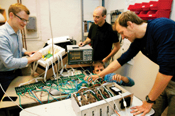 Image: Particle physicists Erlend Bolle, David Volgyes, Michael Rissi and Kim-Eigard Hines, developers of the new technology that enables multiple improvements, including 50 % less radiation from a PET scanner. (Photo courtesy of Yngve Vogt, University of Oslo.)